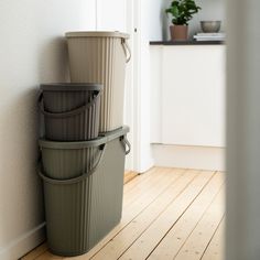 three buckets are stacked up against the wall