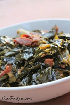 a white bowl filled with collard greens and bacon