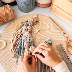 a woman is working with yarn and crochet on a table next to other crafting supplies