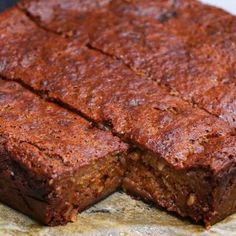 two pieces of brownie sitting on top of a piece of parchment paper