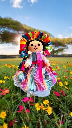 a doll is standing in the middle of a field full of flowers and daisies