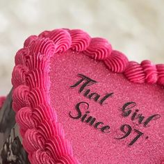 a pink heart shaped cake with the words that girl since 91 on it's side