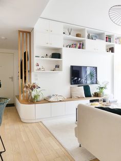 a living room filled with furniture and a flat screen tv mounted on a wall above a fireplace