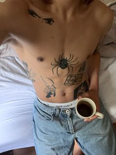 a shirtless man holding a cup of coffee