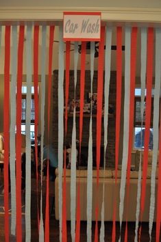 a room with red and white streamers hanging from it's walls, in front of a couch