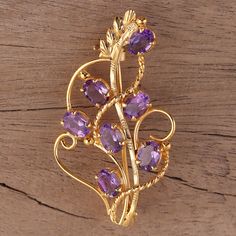 The allure of lilac blooms entices in this beautiful 22k gold plated sterling silver brooch. Indian designer Alok Jain brings to life this gemstone-filled bouquet, with seven total carats of amethyst gemstones serving as purple lilac blooms, surrounded by intricately crafted floral design work. Purple Gemstone Brooches For Gift, Lavender Brooch Jewelry As A Gift, Purple Amethyst Brooch For Gift, Purple Amethyst Brooch As A Gift, Elegant Gold Amethyst Brooches, Amethyst Brooch, Citrine Pendant, Ruby Pendant, Garnet Pendant