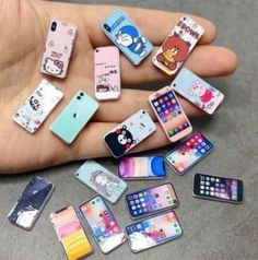 a hand holding a bunch of cell phones in it's palm, with other cases on the ground