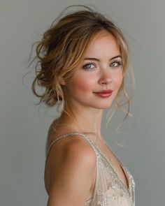 a woman wearing a white dress and posing for a photo with her hair blowing in the wind