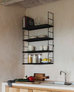 a kitchen area with a sink and shelves above it