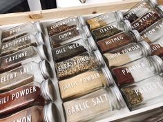 spices in glass containers are lined up on a counter top with labels that spell out different types of seasonings