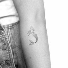 a small mermaid tattoo on the left forearm and right arm, with a fish in it's tail