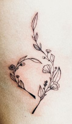 a close up of a tattoo on the back of a woman's stomach with flowers growing out of it