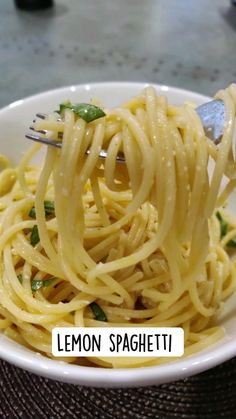 a white bowl filled with lemon spaghetti on top of a table