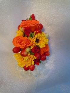 an orange and yellow bouquet on a white tablecloth with flowers in the center,