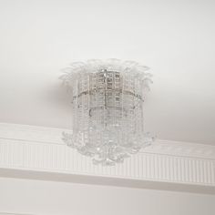 a chandelier hanging from the ceiling in a room with white walls and trim