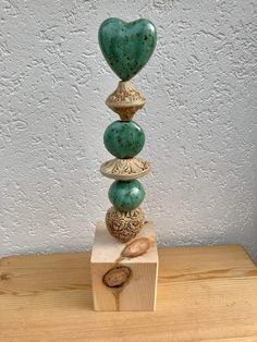 a stack of stones sitting on top of a wooden table next to a white wall