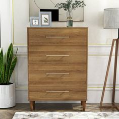 a wooden dresser sitting next to a potted plant