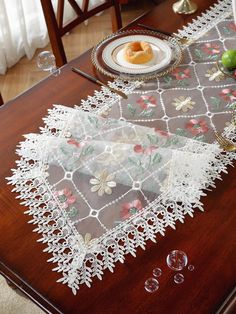 the table is covered with lace and fruit