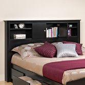 a bed with a bookcase headboard and two pillows on top of the bed