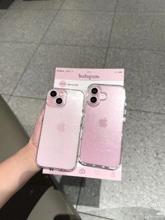 two pink iphone cases sitting on top of each other in front of a display case