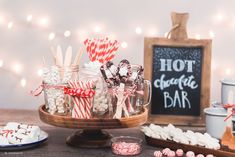 candy bar with hot chocolate and marshmallows in glass jars on wooden tray