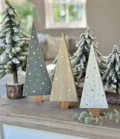 three wooden christmas trees sitting on top of a table