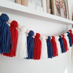 red, white and blue tasselled garland hanging on wall next to framed pictures