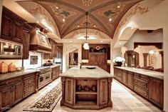 a large kitchen with wooden cabinets and marble counter tops, along with an ornate ceiling