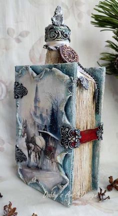 an altered book with a bird on top of it and some pine cones in the background