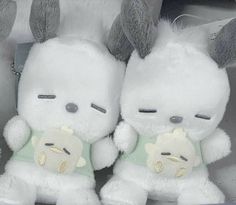 two white stuffed animals sitting next to each other