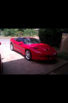 a red sports car parked in a driveway