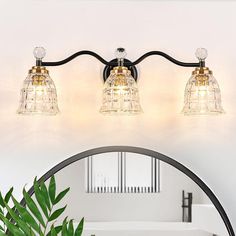 three light bathroom vanity fixture with clear glass bell shades and black metal trimmings