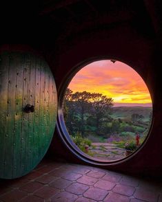 two round windows with the view of a beautiful sunset in them, and one is open