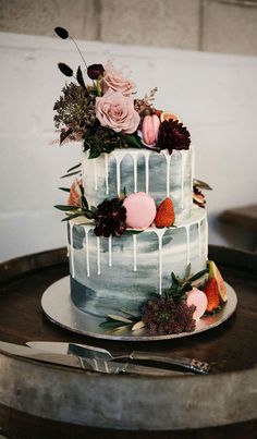 a three tiered cake sitting on top of a table next to a wine barrel