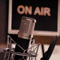 an old fashioned microphone sits in front of a television screen with the word on air written above it