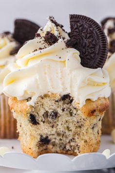 an oreo cookie cupcake with cream frosting and cookies on top is ready to be eaten