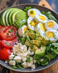 a salad with hard boiled eggs, tomatoes, avocado and feta cheese