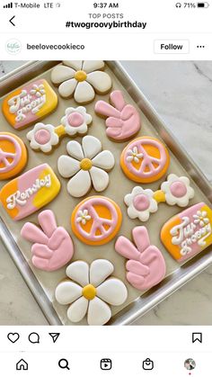 an image of some decorated cookies in the shape of flowers and peace signs on a tray