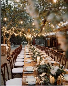 a long table is set up with candles and place settings for an outdoor dinner party