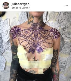 a woman with lots of tattoos on her back and chest is posing for the camera