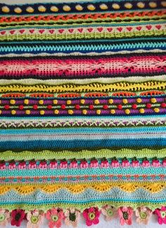 a pile of multicolored crocheted afghans