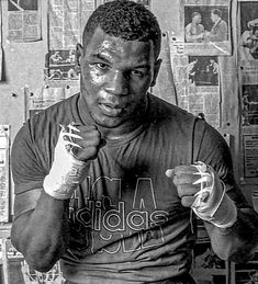 a black and white photo of a man with boxing gloves on holding his fists up