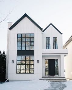 a white house with lots of windows and snow on the ground