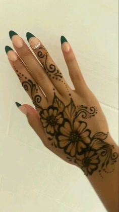 a woman's hand with henna tattoos on it