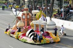 a parade float with people riding on it's back in the middle of the street