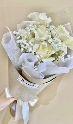 a bouquet of white flowers wrapped in paper