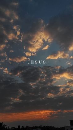 the word jesus is written in front of a cloudy sky