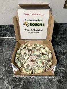 a pizza in a cardboard box with money on it and a sign that says sorry, i ate the pizza but there's plenty of dough $ 3 happy birthdays