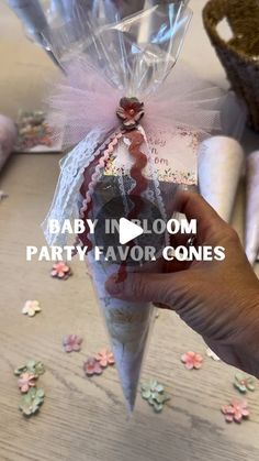 someone is holding a party favors wrapped in cellophane and pink ribbon with the words, baby in bloom party favors