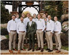 a group of men standing next to each other wearing white shirts and khaki pants